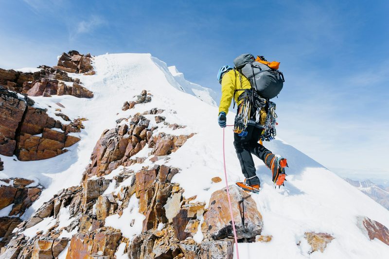 Man hiking a mountain with crampons
