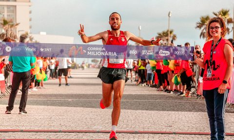 Happy man smiling crossing marathon finish line