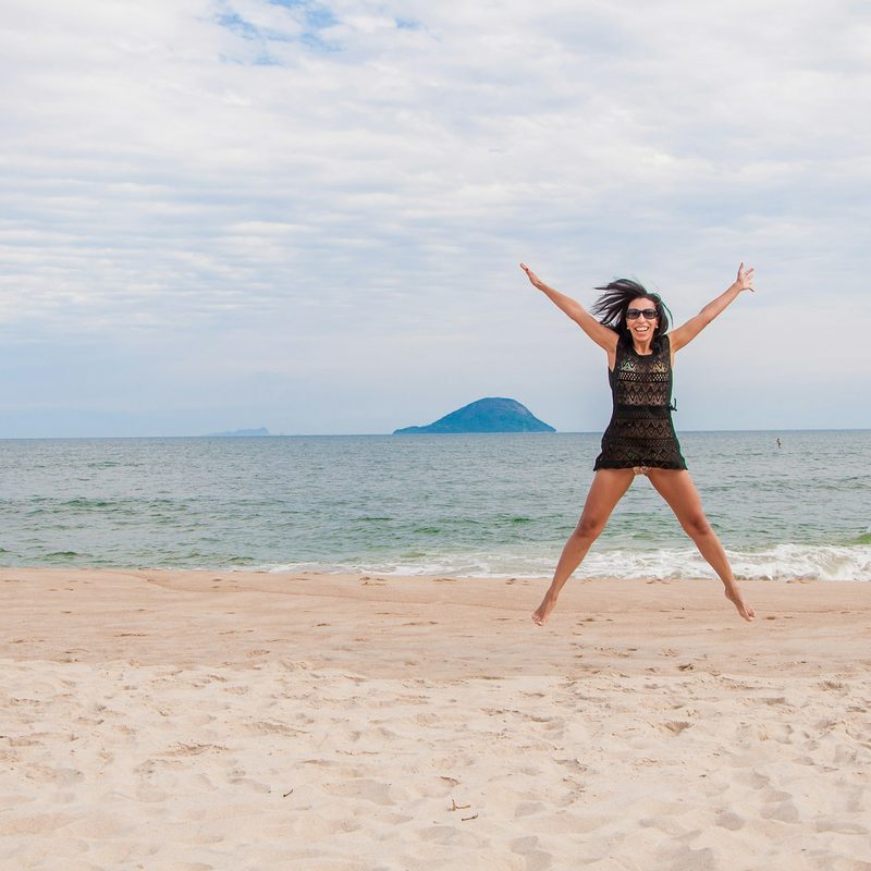 Woman jumping outside on a beach