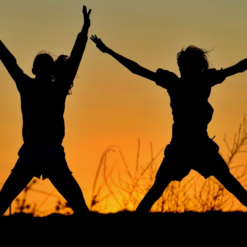 Women doing Jumping jacks at sunset