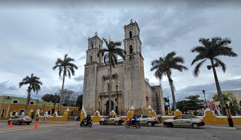 The main square in Vallolidad, Mexico, featuring an old church and tall palm trees
