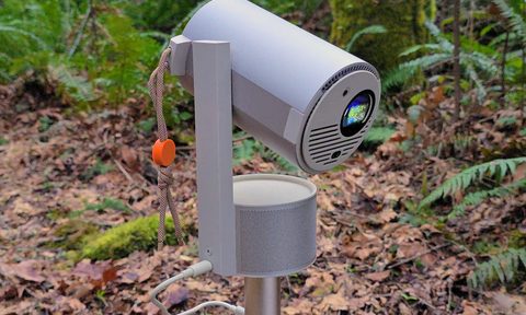 XGIMI projector in the woods with turned on lens