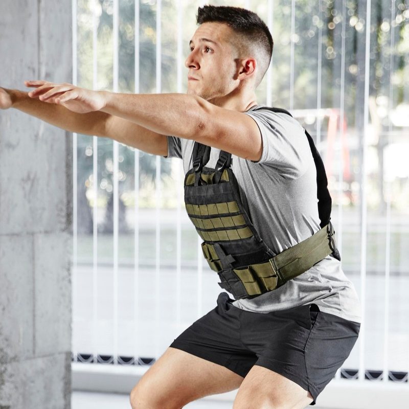 Man squatting with weighted vest