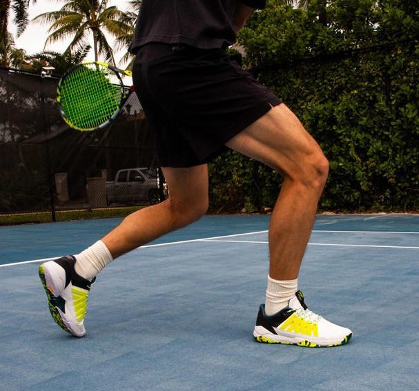 man playing tennis with p448 sneakers