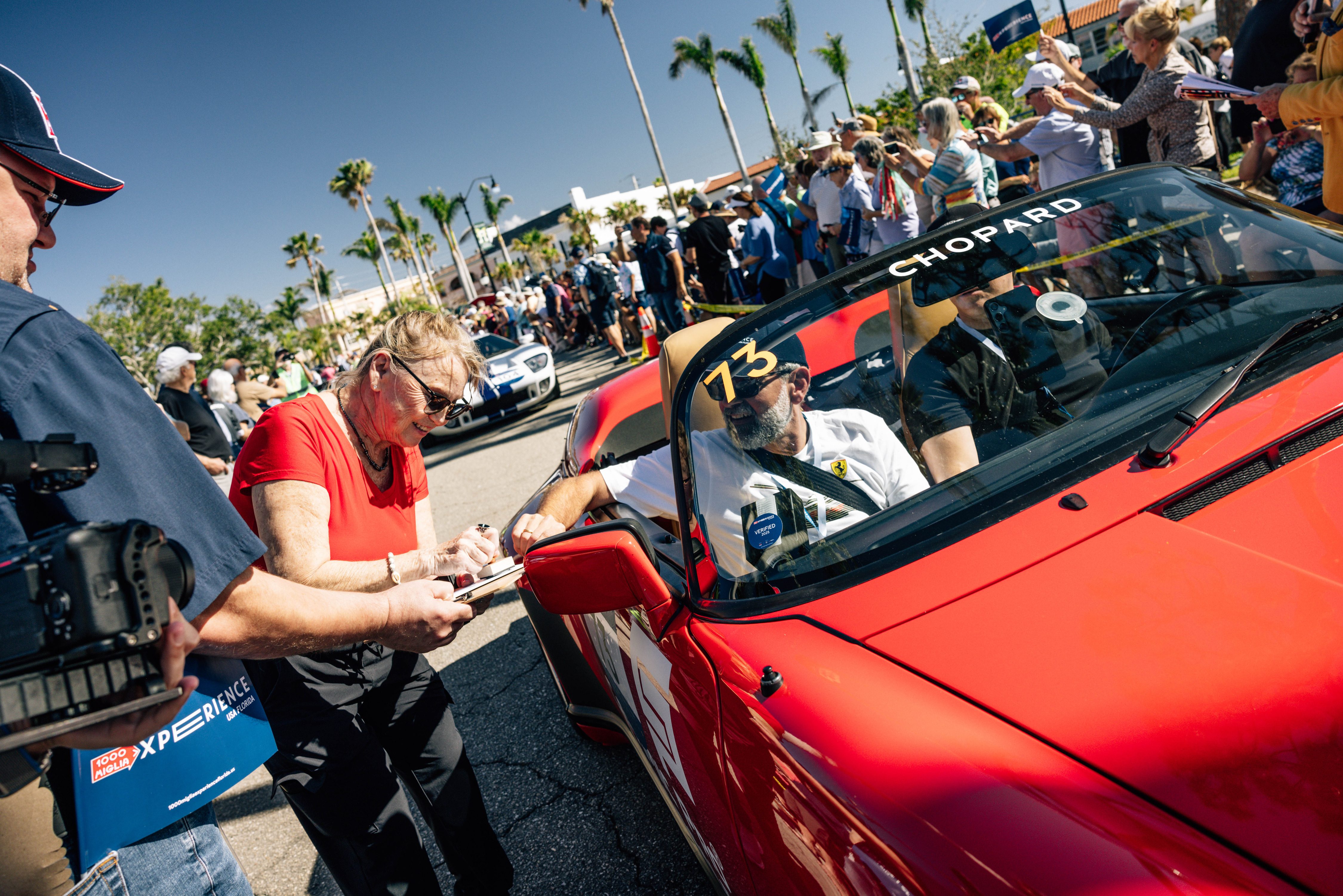 A Porsche 911 passenger pointing at a clipboard during the 1000 Miglia Experience Florida