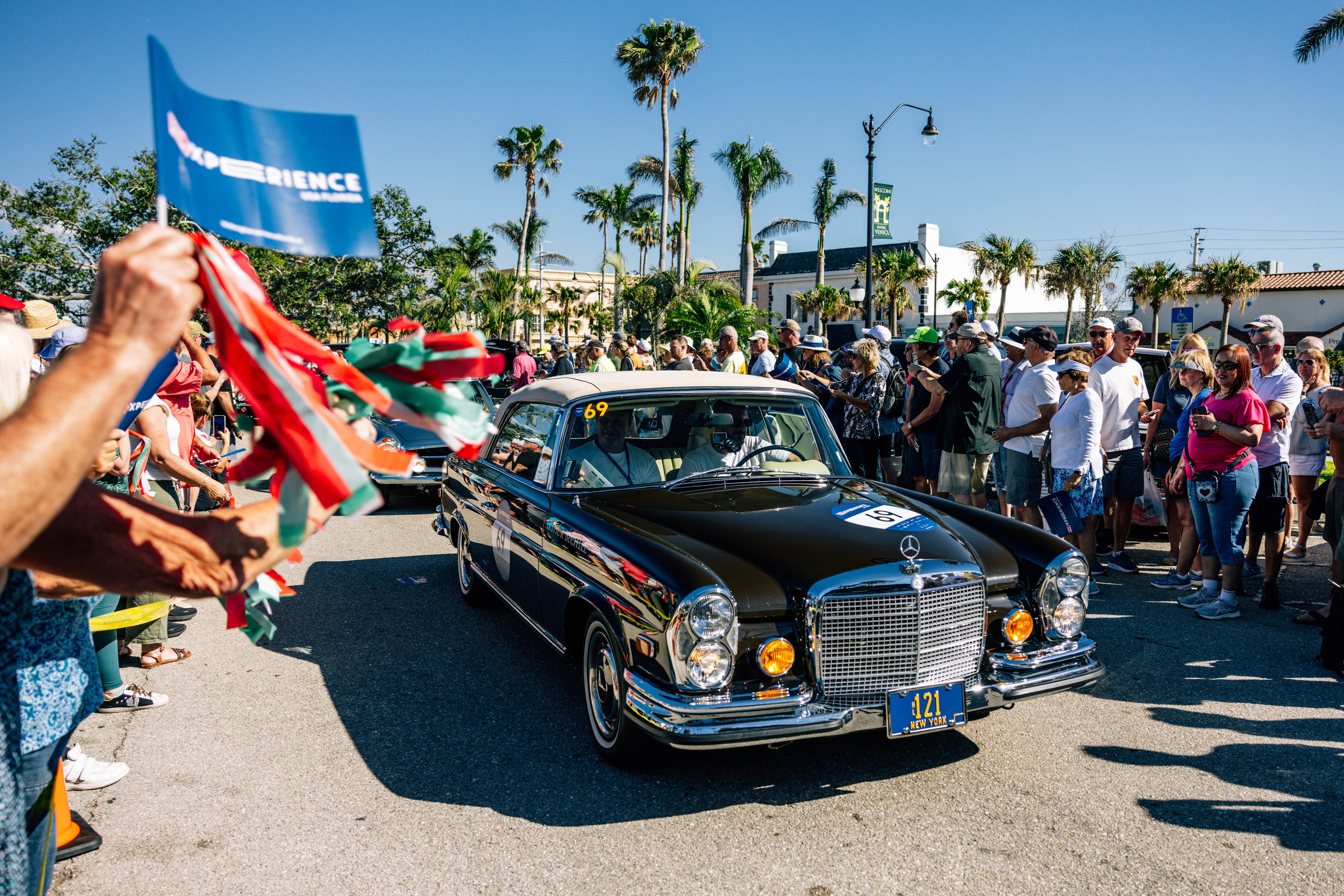 A Mercedes-Benz 280 SE driving through the crowd at the 1000 Miglia Experience Florida