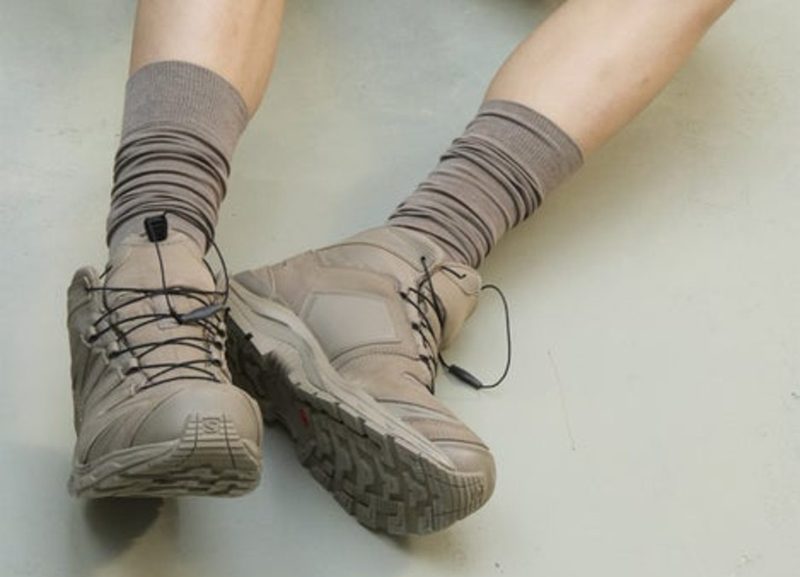 person laying down with salomon clay trail boot
