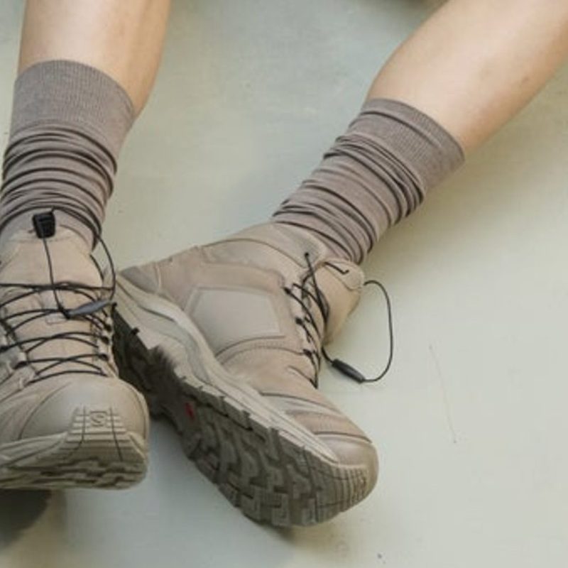 Person laying down with Salomon clay trail boots
