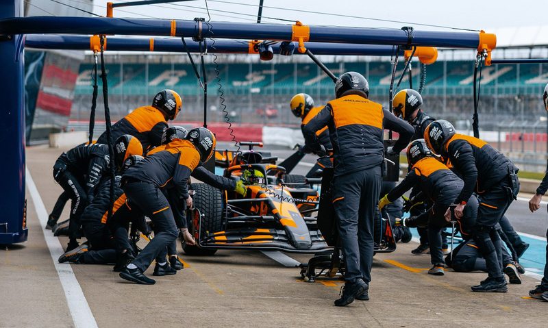 McLaren 2025 F1 race car about to have a pit crew tire change.