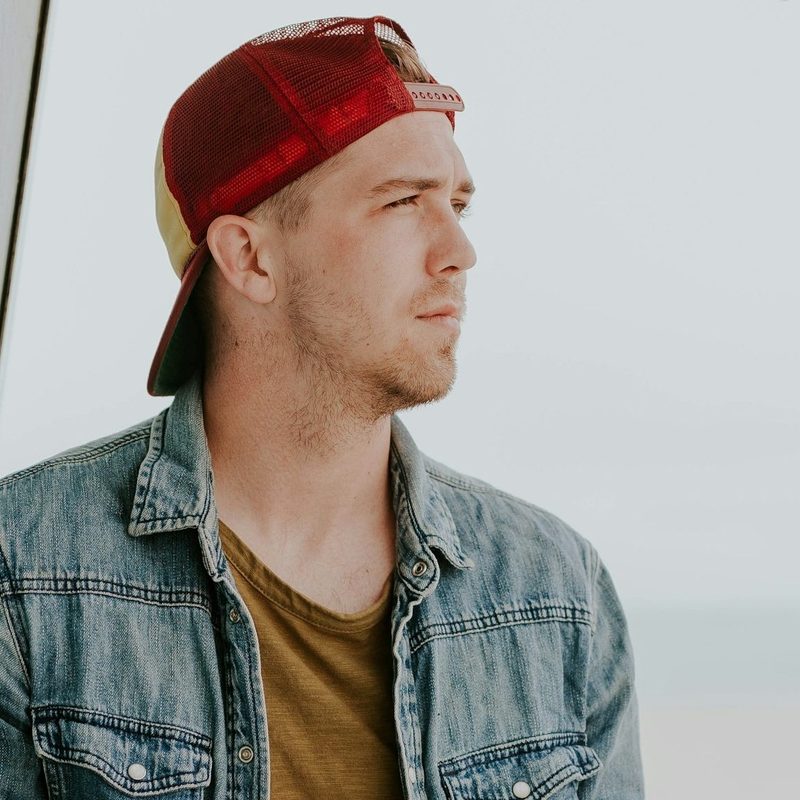 M an wearing backwards cap thinking