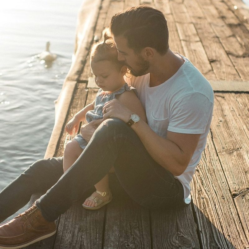 Man with child on a pier by the water