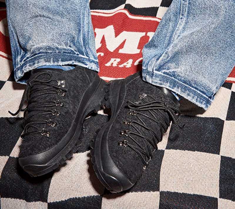 man wearing urban trail boots on checkered floor