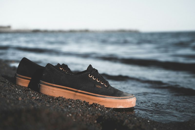 black canvas sneakers on beach
