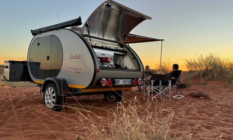 Naledi teardrop travel trailer/camper parked at a desert camp.