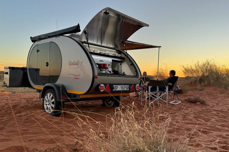 Naledi teardrop travel trailer/camper parked at a desert camp.