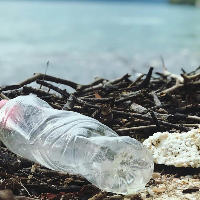 Trash on ocean water bottle beach