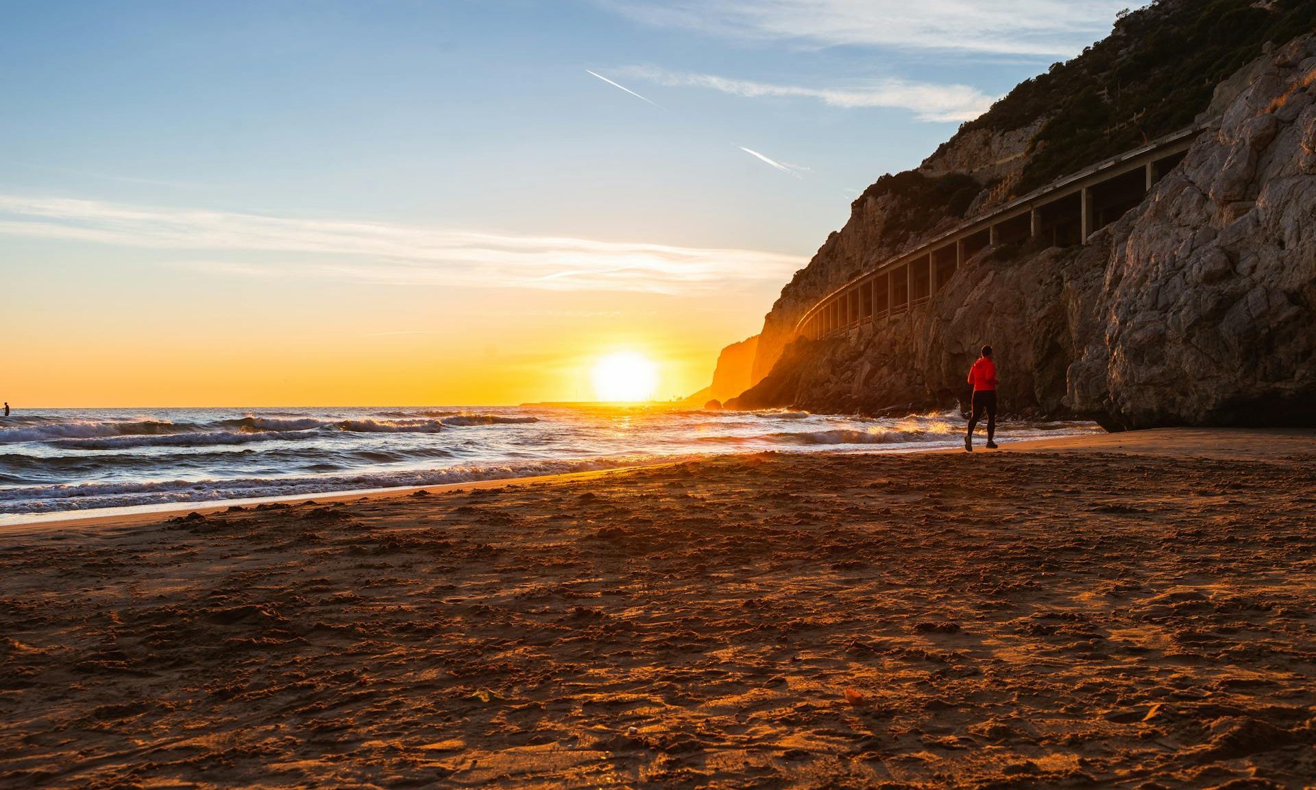 man running on beach at sunset