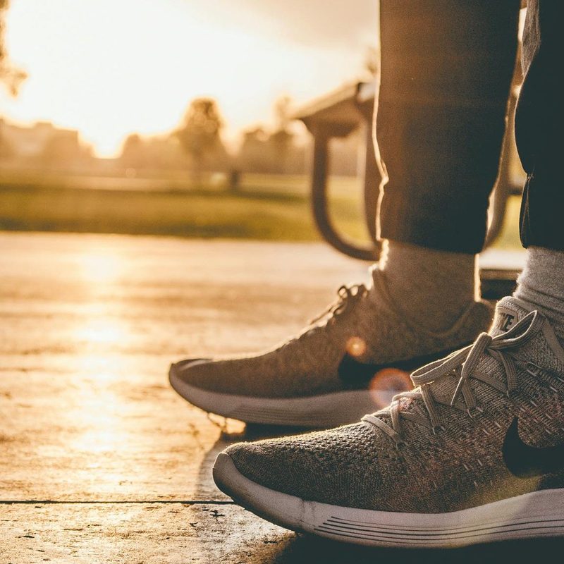 Running shoes sneakers outside park bench sunrise sunset