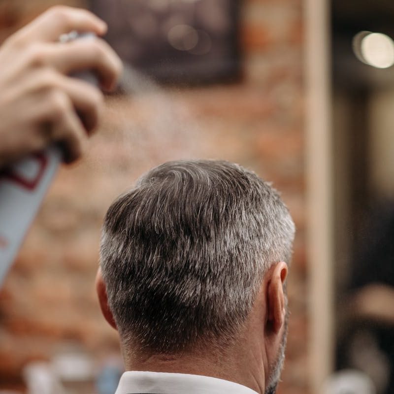 Man getting hair sprayed at barber