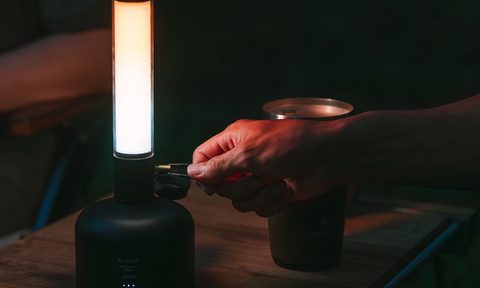Closeup of a hand turning on a Snow Peak GigaPower Tabletop Lantern.
