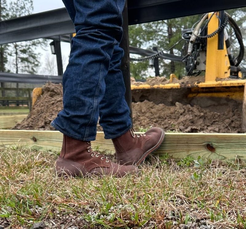 man wearing brown boots in field
