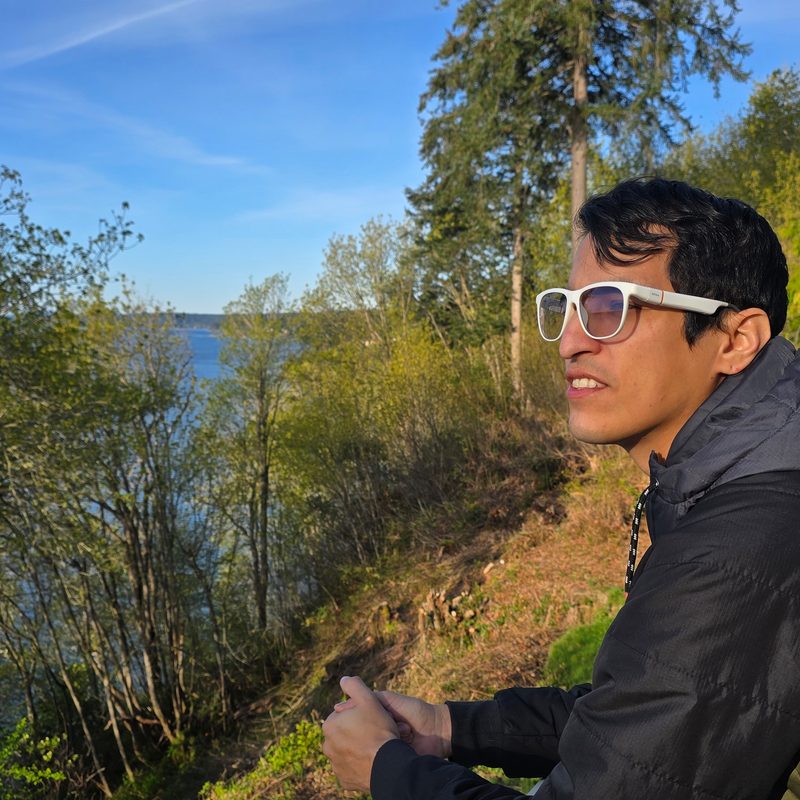 A man wearing solos glasses looking into the woods