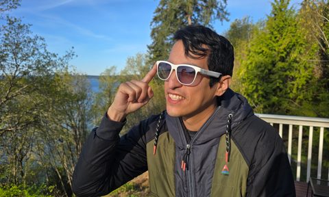 A man wearing solos glasses and pressing the side button to activate them