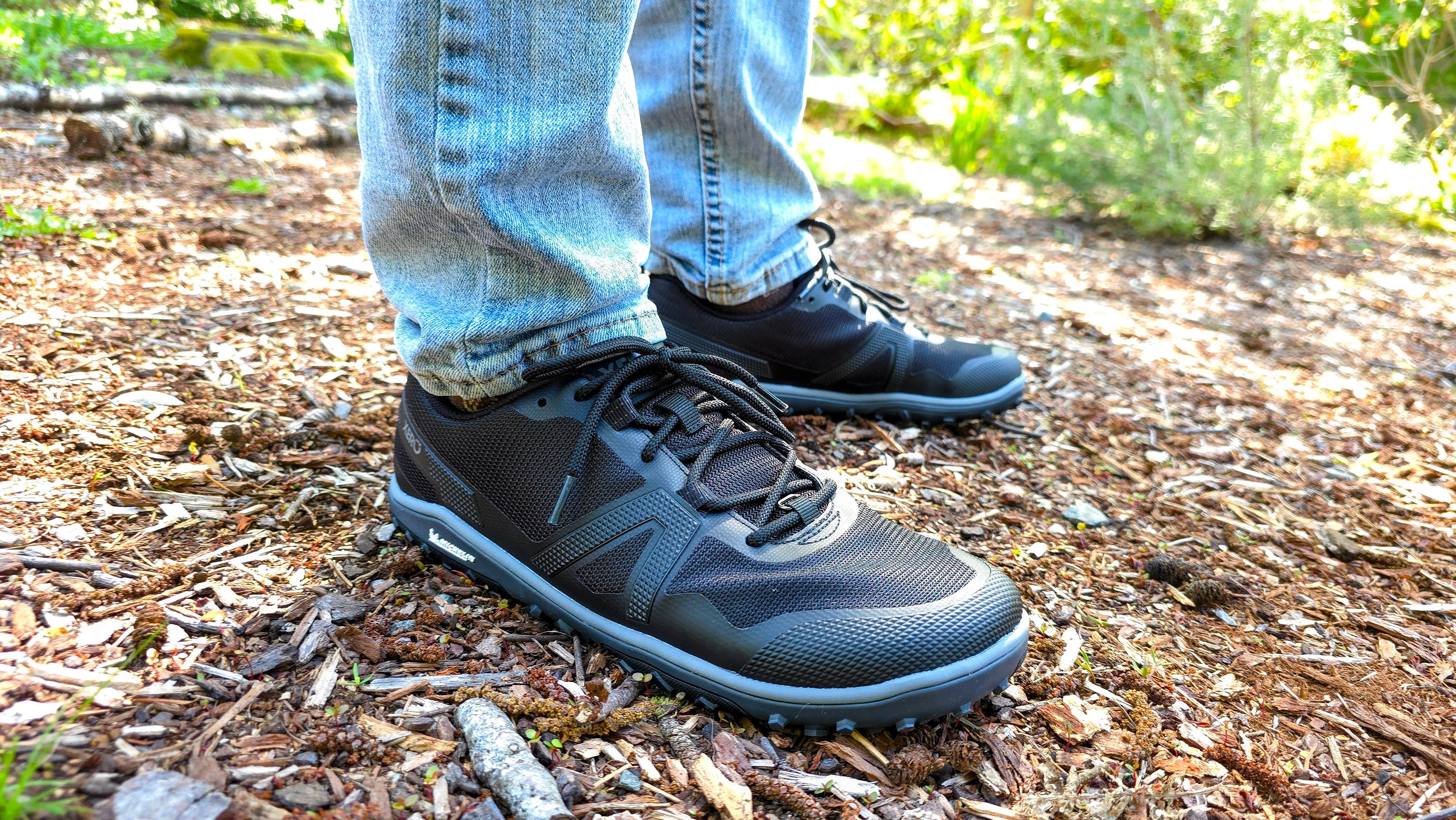 A man wearing Xero shoes while standing still