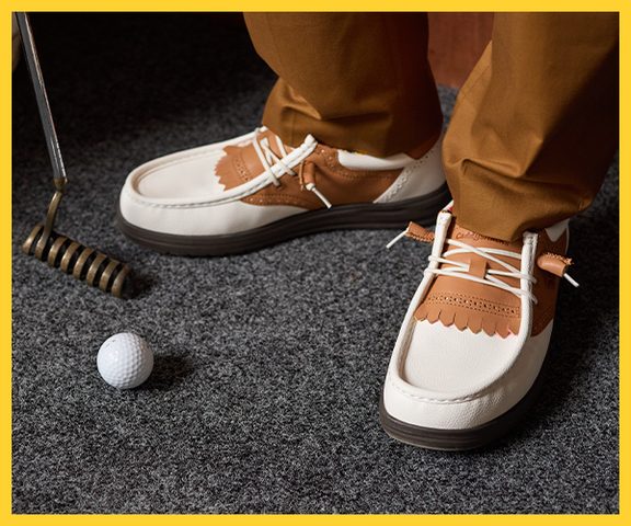 brown and white leather golf shoes