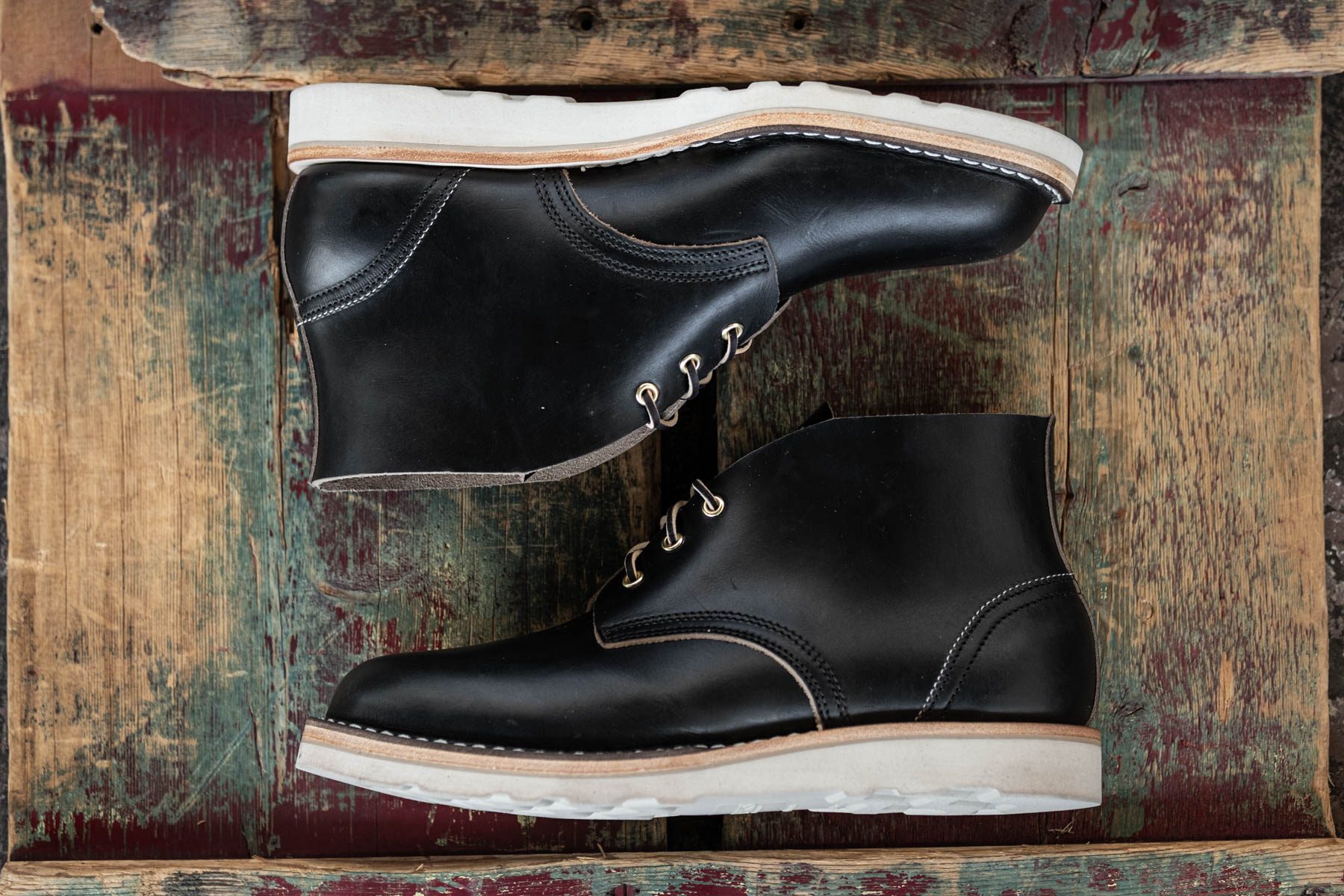 black chukka boots on wood table