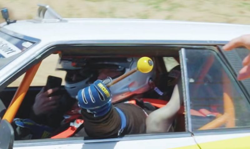 Faruk Kugay shows the gear shift lever that came off during a practice lap at the Hoonigan Rally Speedrun Championship.