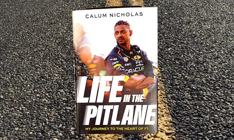 Life in the Pitlane by Calum Nicholas bookcover shot against road with yellow centerlines.