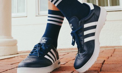person wearing navy adidas golf shoes