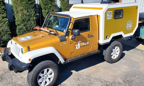 A yellow Jeep Wrangler with Gr8tops' JPOD camper conversion kit installed.