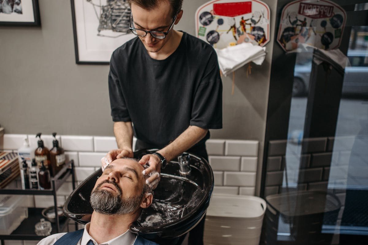 man getting shampoo at barber