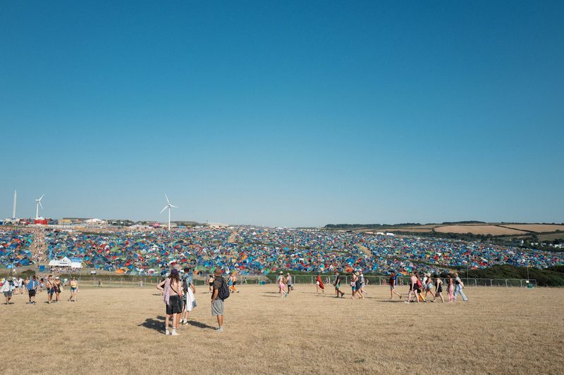 People walking to their festival camping tents