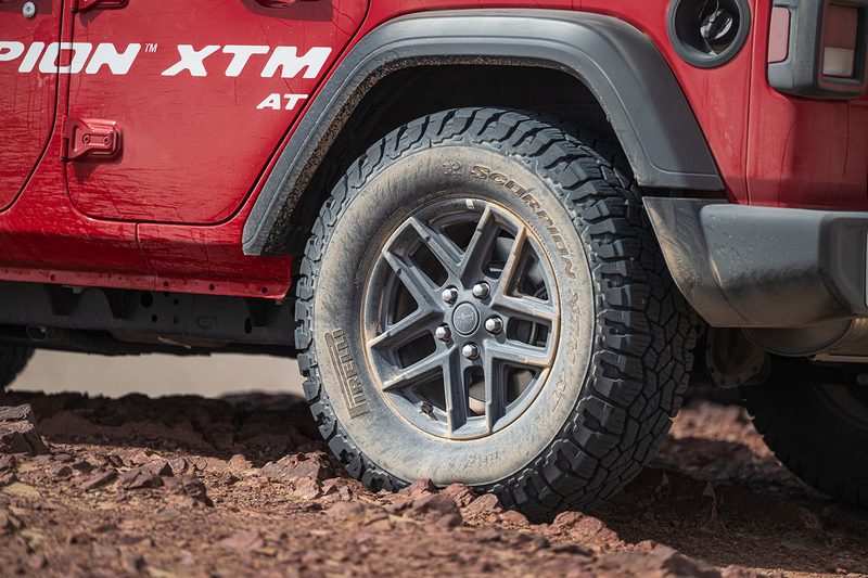 Closeup of a Pirelli Scorpion XTM all-terrain tire on a red Ford Bronco.