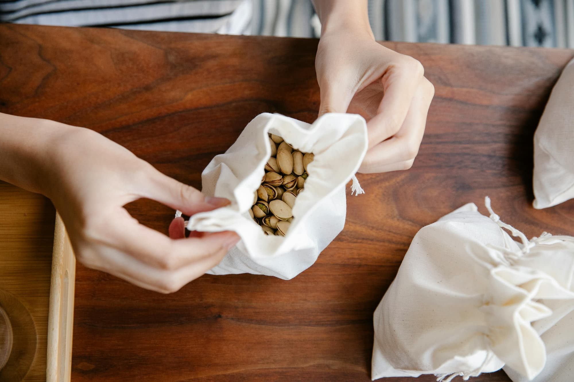 woman holding cloth snack bag with pistachios inside