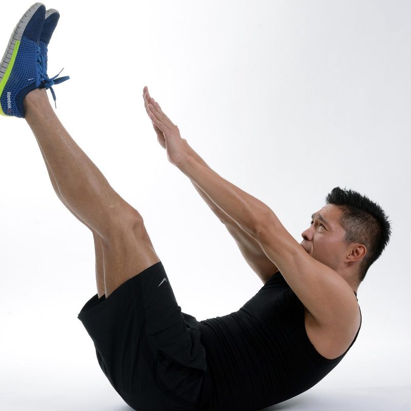 Man doing hollow body hold exercise