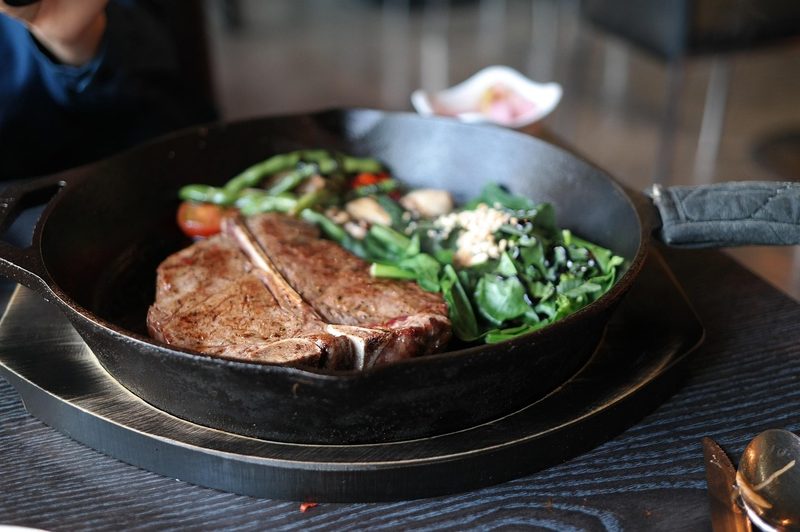 T-Bone steak and spinach in cast iron pan