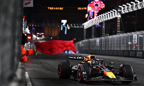 A track marshall waving a red flag at Las Vegas Grand Prix.
