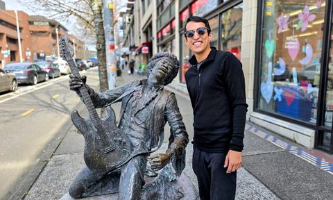 Raul Mercado standing next to Jimi Hendrix Sculpture in Seattle