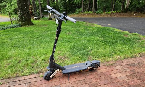 NAVEE ST3 Pro left side with kickstand down on a brick sidewalk with.