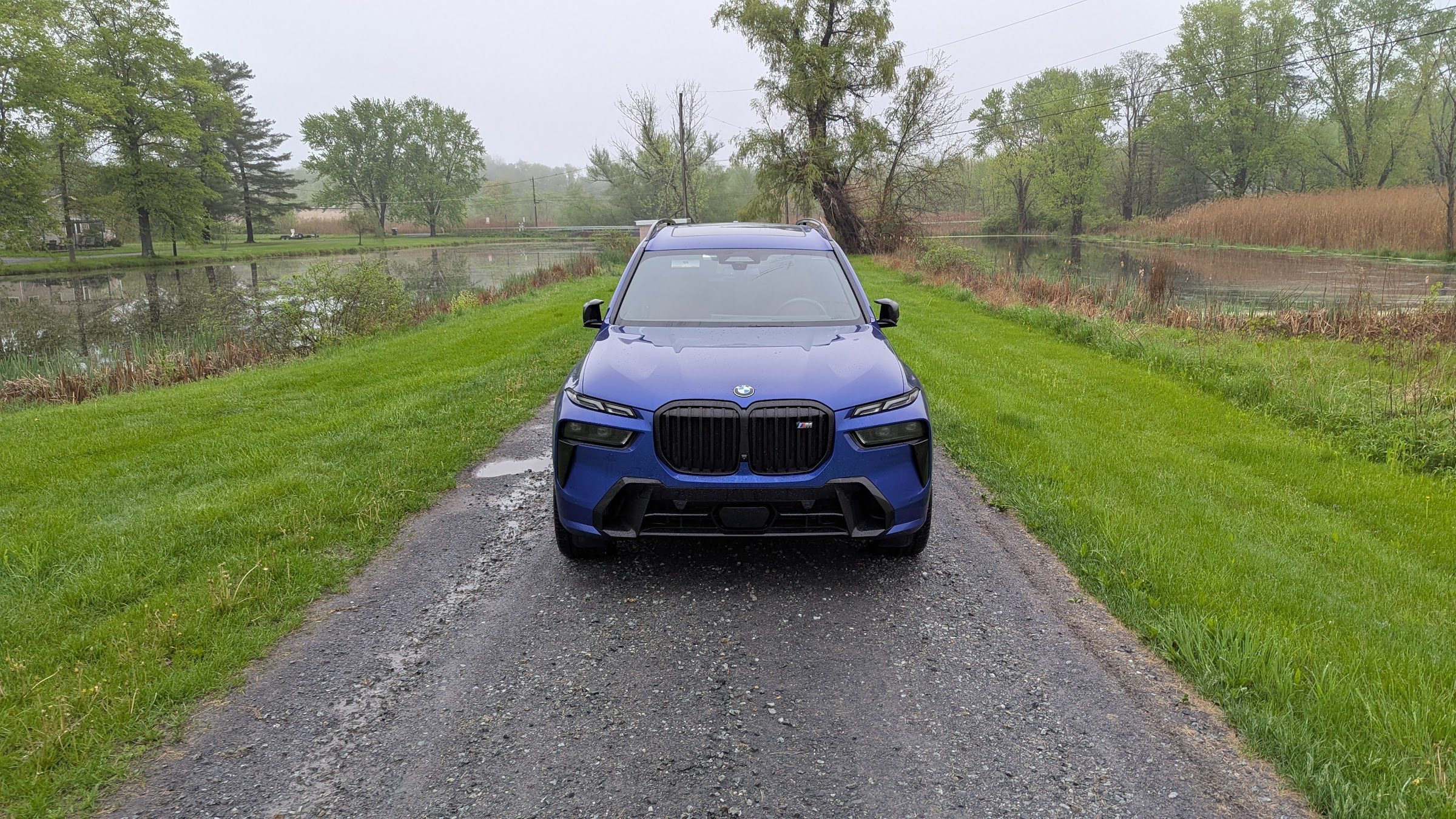 Front view of a a blue BMW X7 M60i