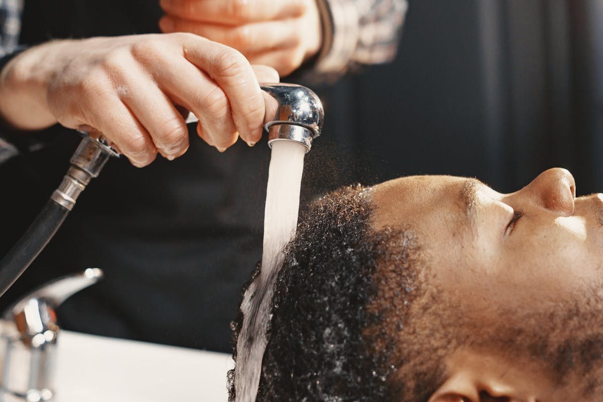 a man getting his hair washed at the barber