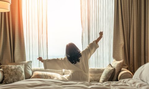 Woman waking up in hotel room