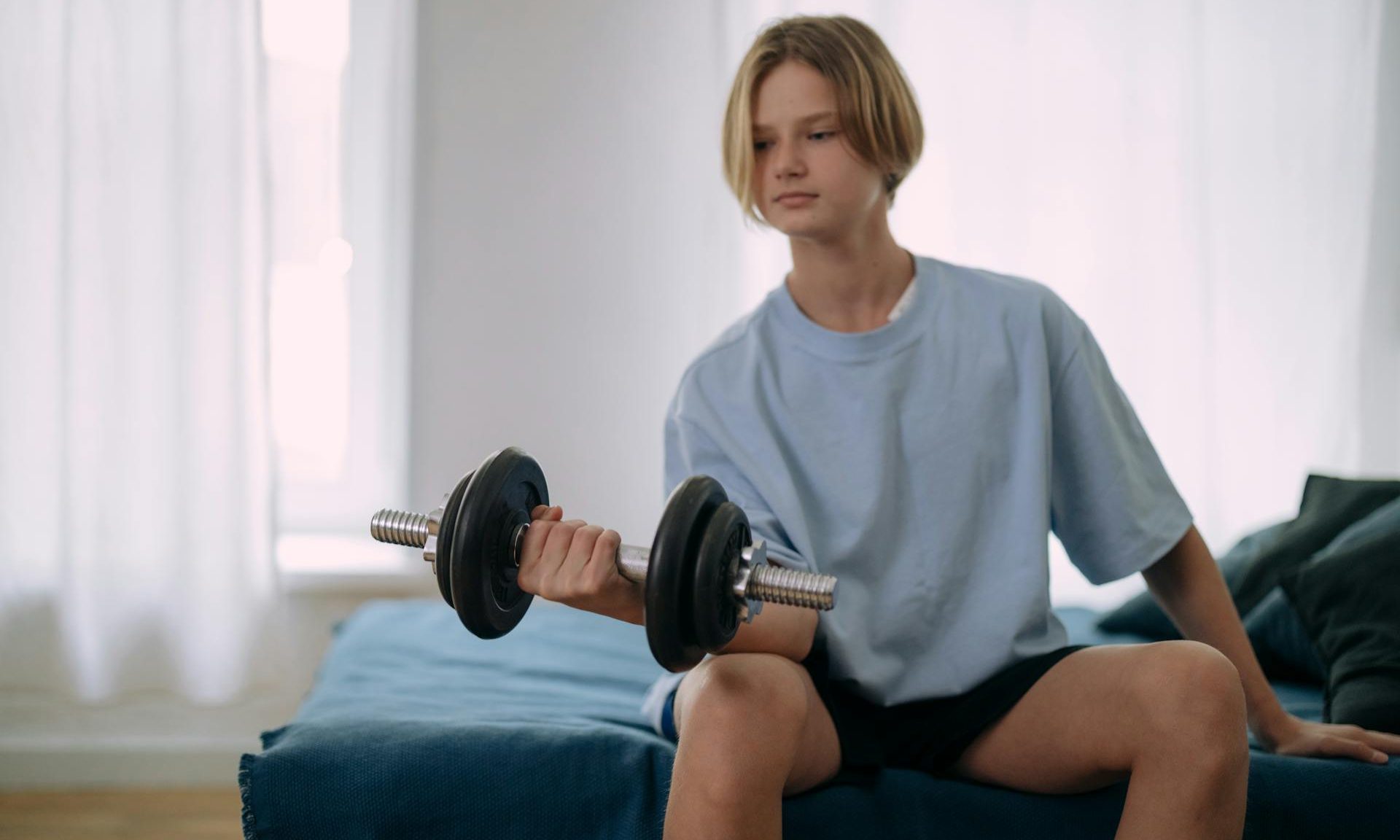 teenage boy adolescent lifting weights bicep cur