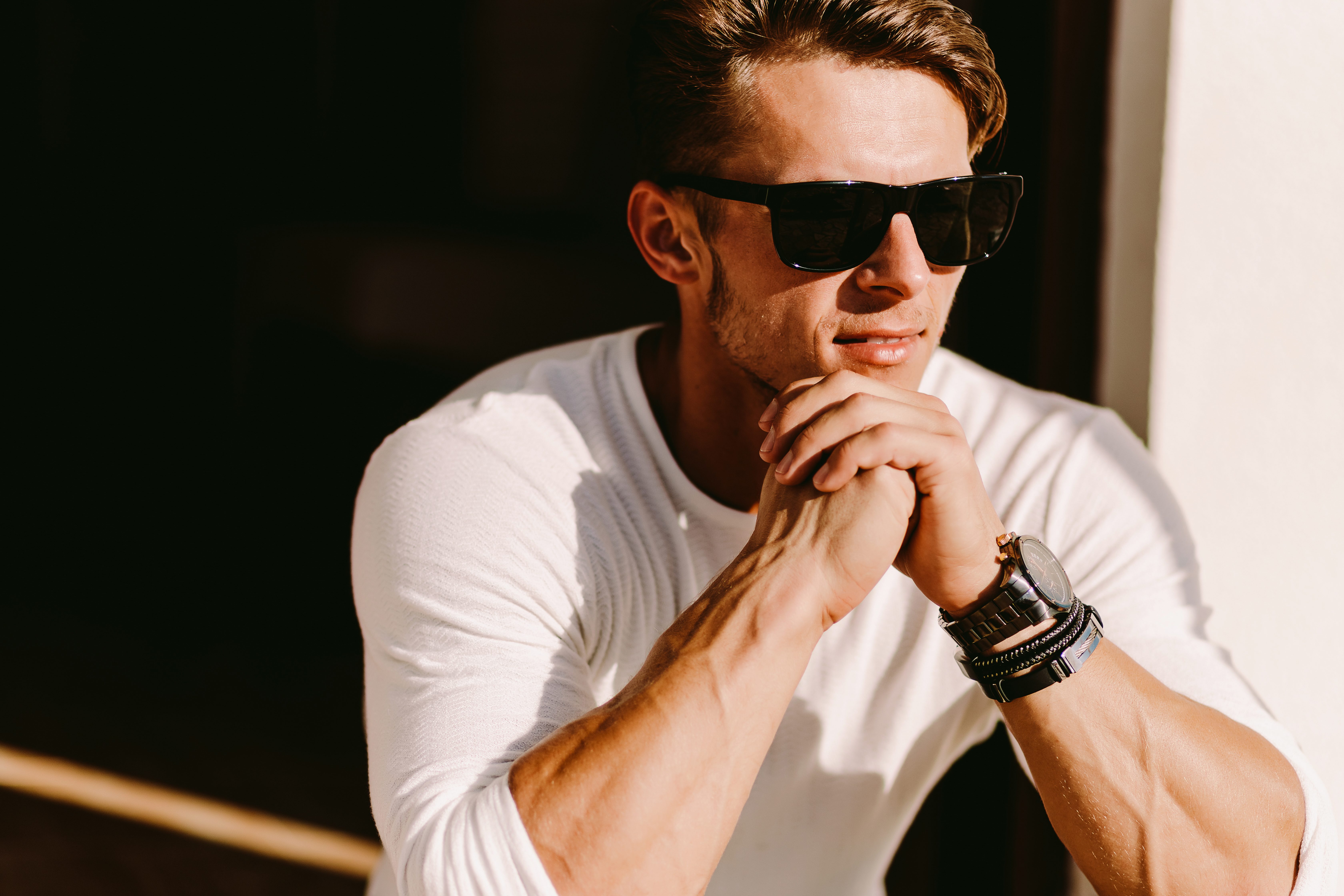 portrait of a handsome man in sunglasses and watch outdoors.