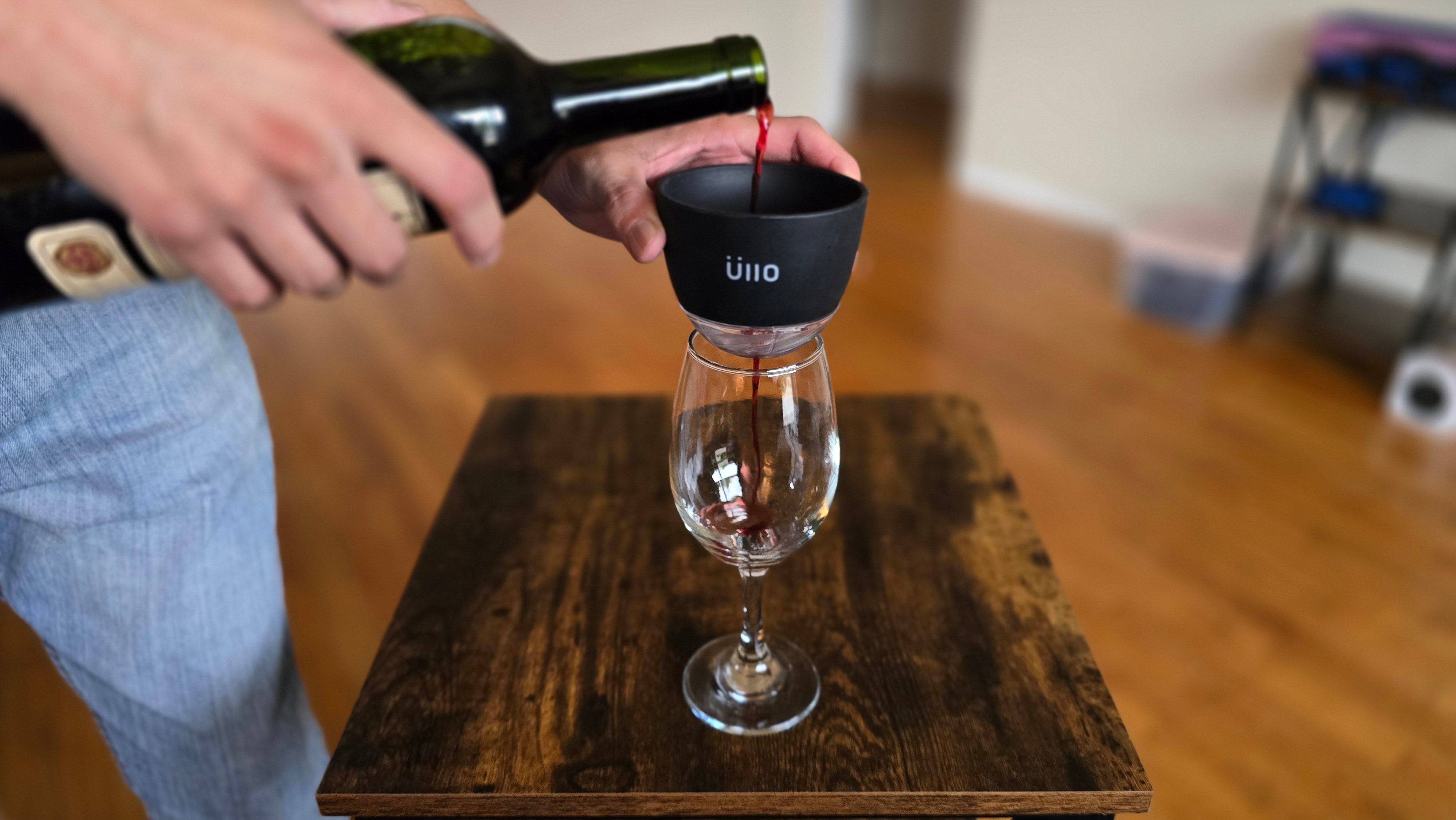 The Ullo Purifier held above a glass