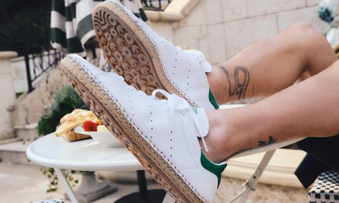 man wearing white adidas stan smith sneakers